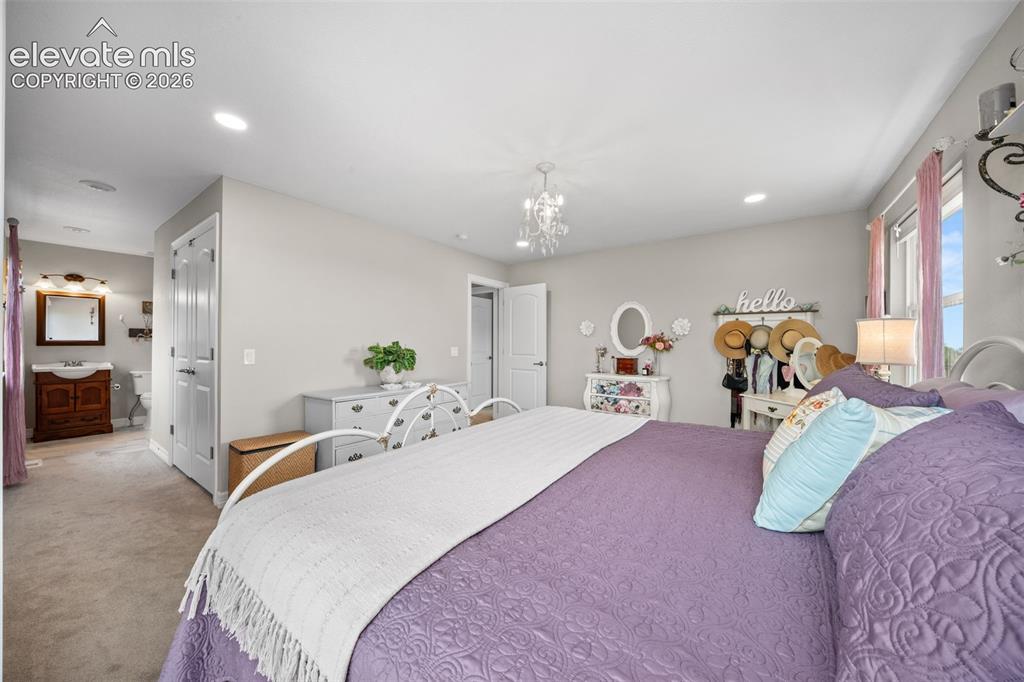 Image 20 of 50: Spacious bedroom featuring light neutral wall tones, recessed lighting, and