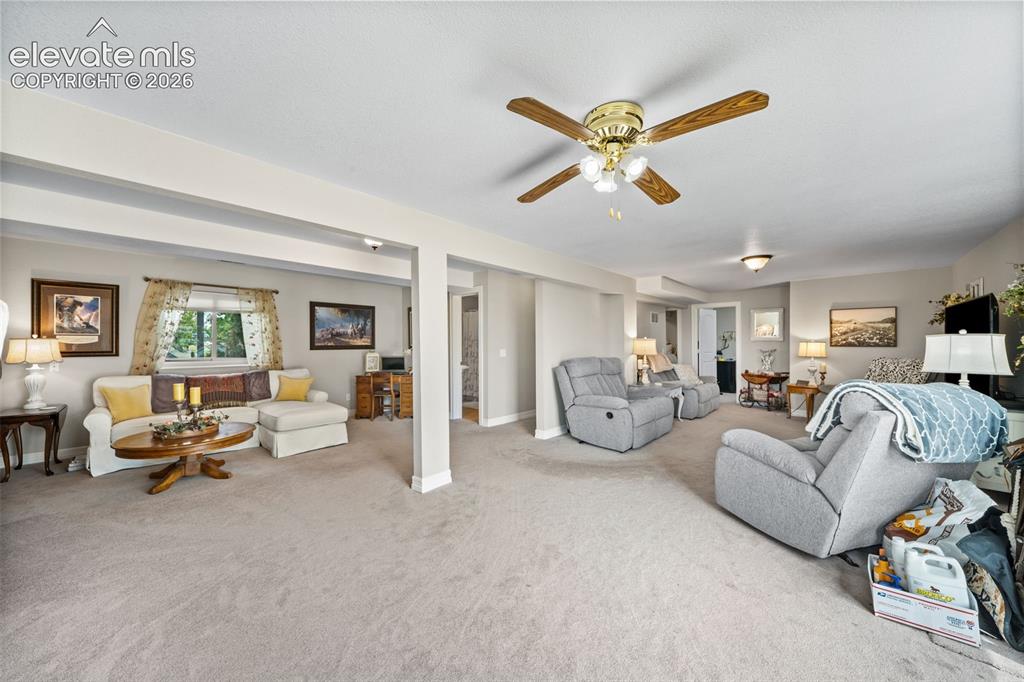 Image 25 of 50: Spacious living area featuring light-toned carpeting, recessed lighting, an