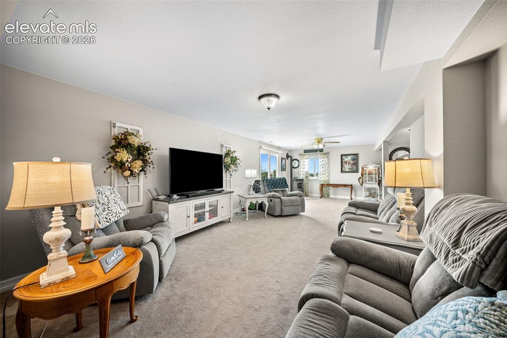 Image 28 of 50: Expansive living area featuring light gray walls, plush carpeting, and rece