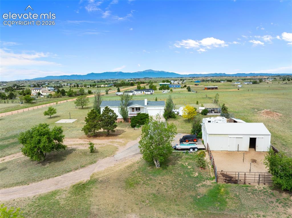 Image 47 of 50: Sprawling rural property featuring a white residence with a gabled roof, an