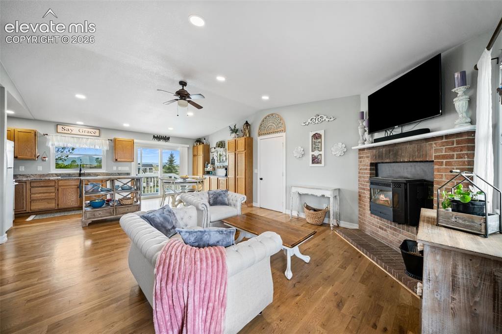 Image 8 of 50: Open-concept living area featuring wood-finish flooring, recessed lighting,