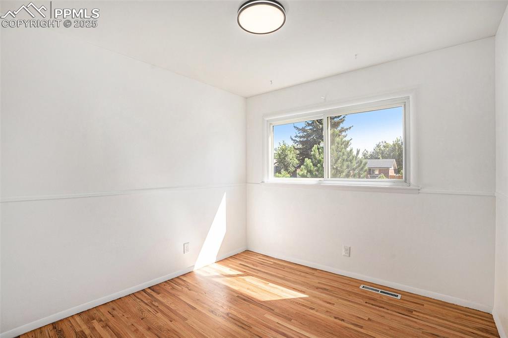 Image 10 of 24: Empty room with light wood finished floors and baseboards