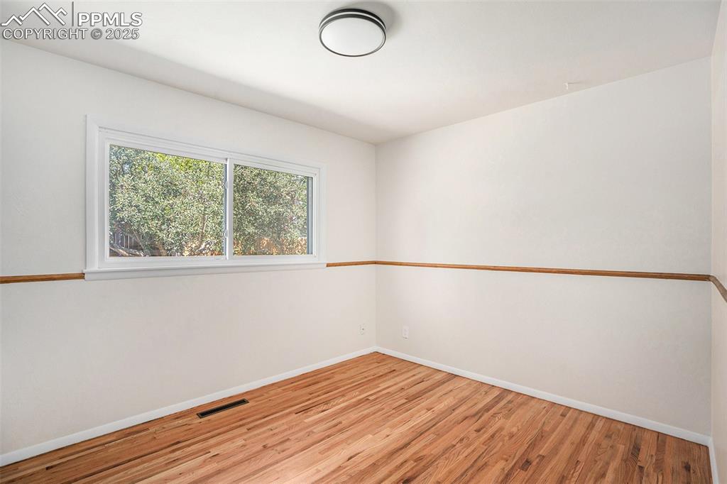Image 11 of 24: Spare room with light wood-style floors and baseboards