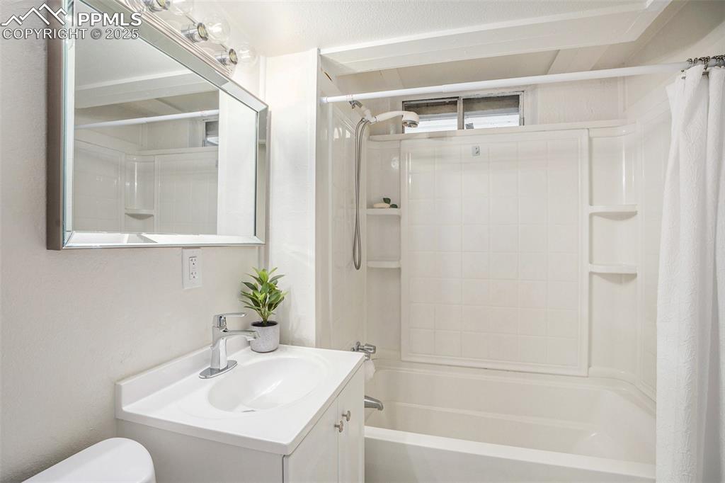 Image 15 of 24: Full bath with shower / bath combo with shower curtain and vanity