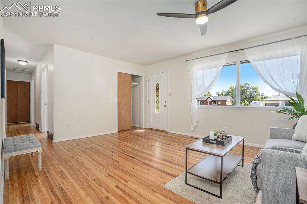 Image 5 of 24: Living room with light wood-type flooring and ceiling fan