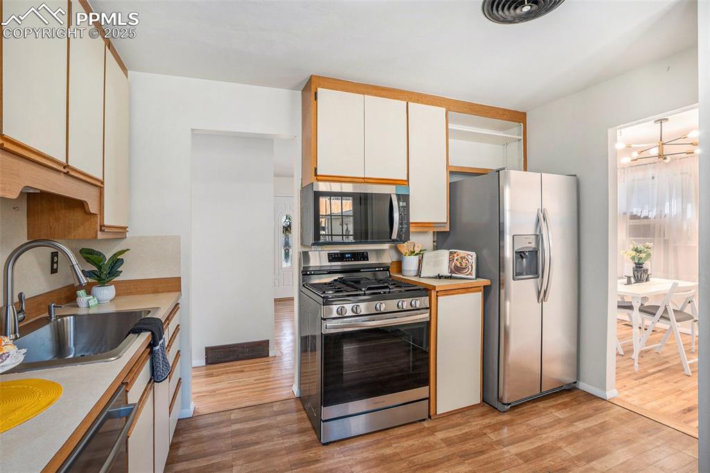 Image 8 of 24: Kitchen featuring stainless steel appliances, light countertops, light wood