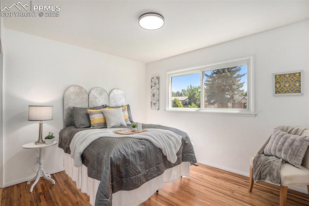 Image 9 of 24: Bedroom with wood finished floors and baseboards