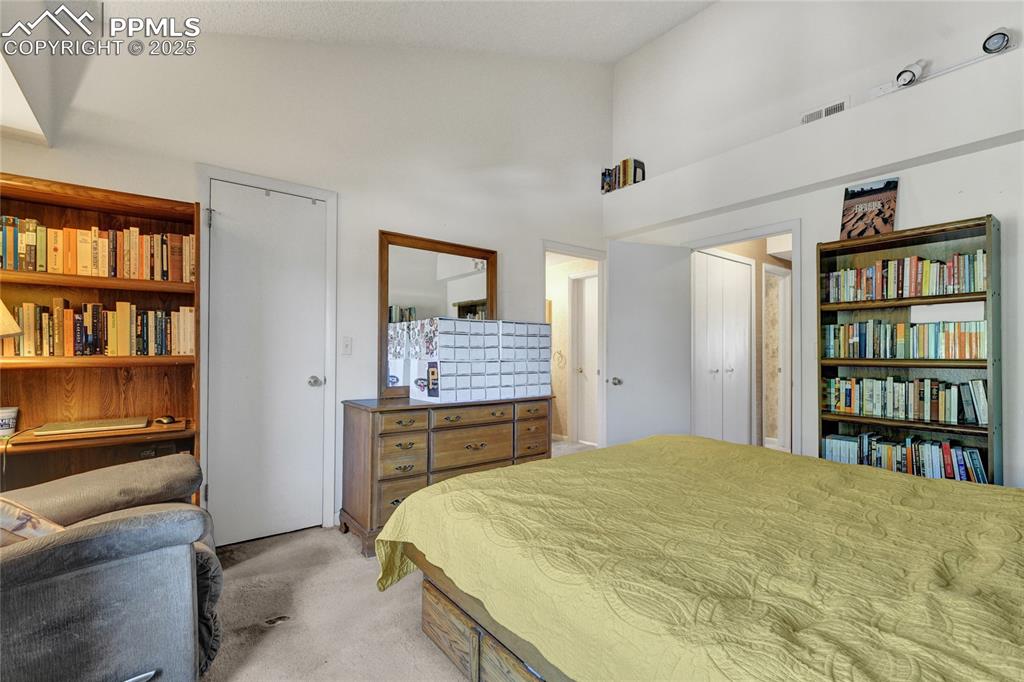 Image 12 of 22: Bedroom featuring light colored carpet and a towering ceiling