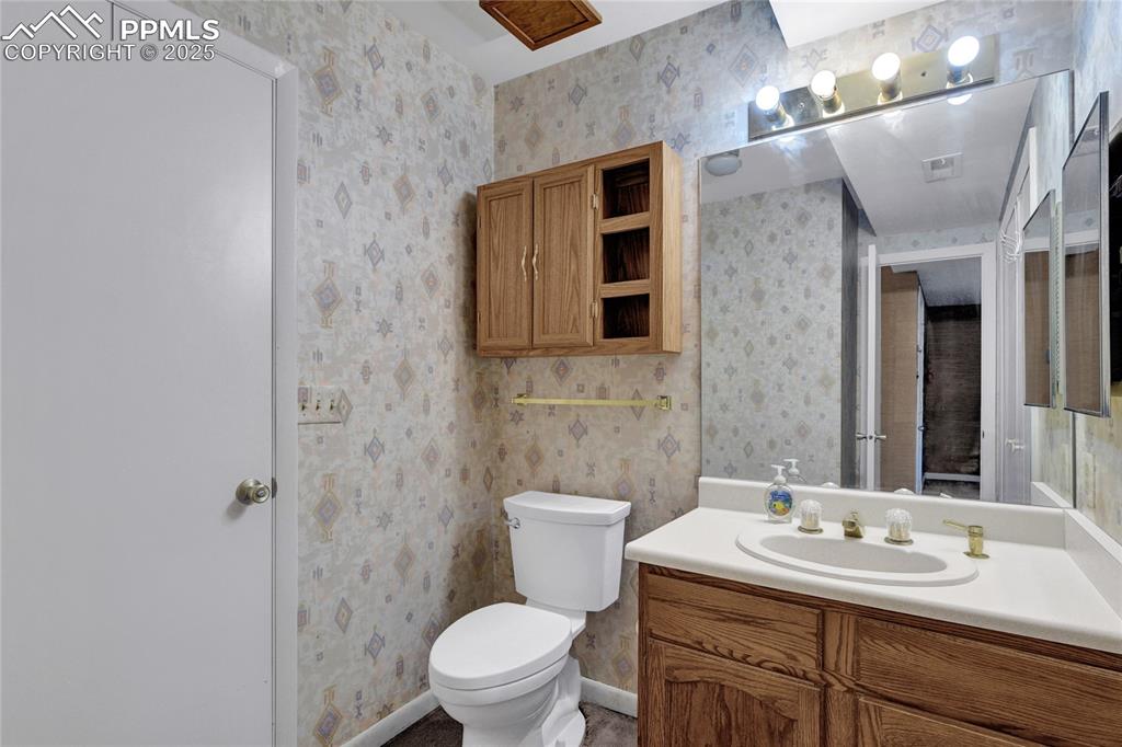 Image 14 of 22: Bathroom featuring vanity and wallpapered walls