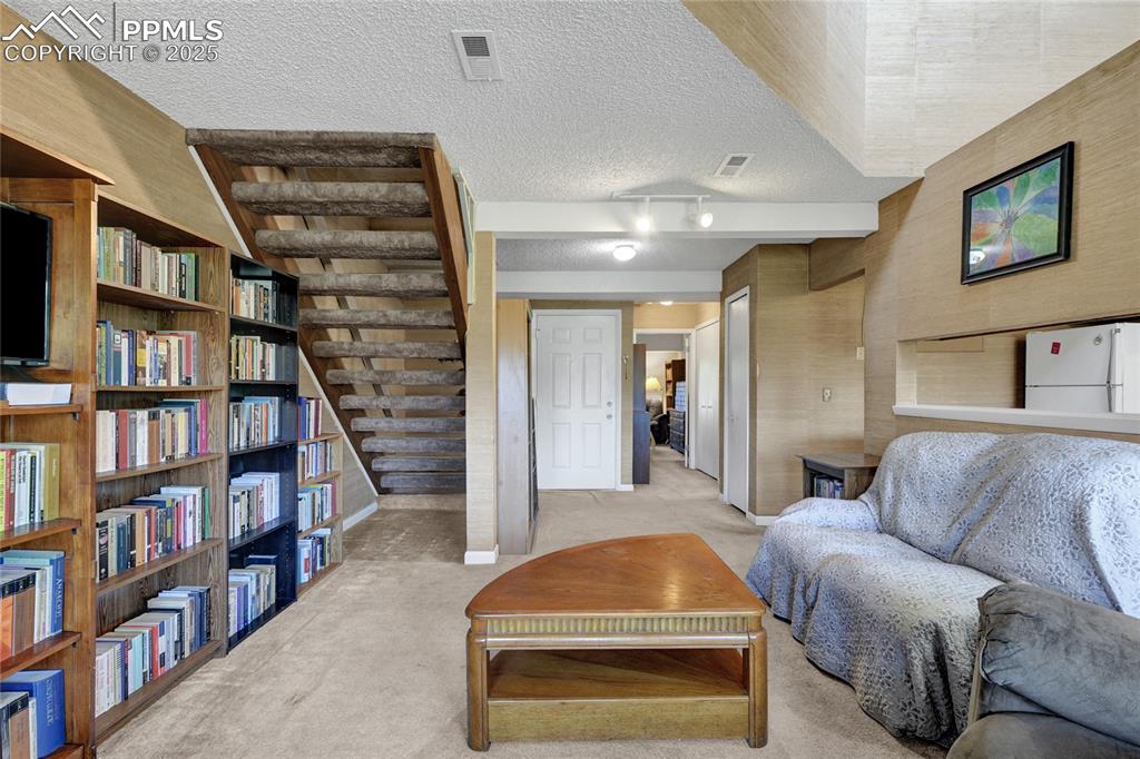 Image 7 of 22: Living area showing stars to loft bedroom and main bedroom
