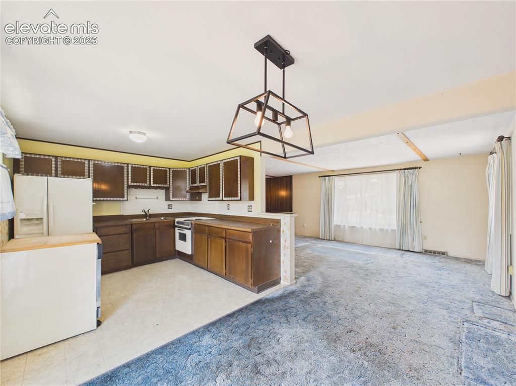 Image 10 of 50: Functional kitchen features generous cabinet storage, wraparound countertop