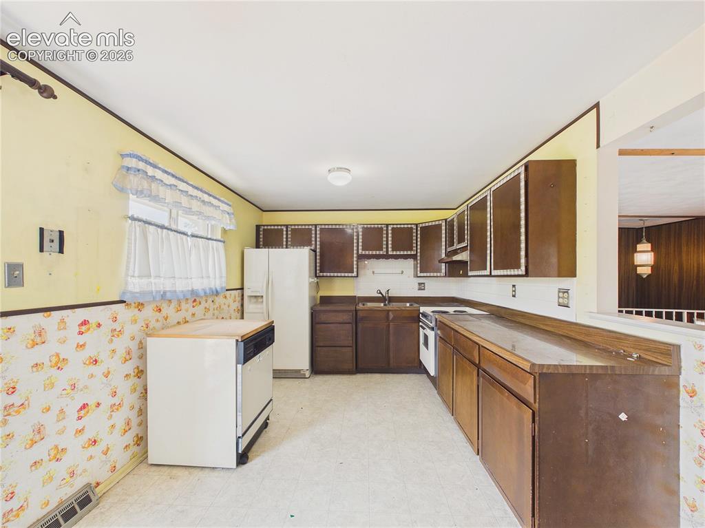 Image 11 of 50: Functional kitchen includes abundant cabinetry, generous counter space, and