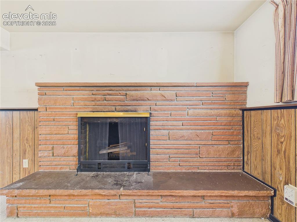 Image 21 of 50: Floor-to-ceiling stone fireplace serves as a timeless centerpiece, adding c