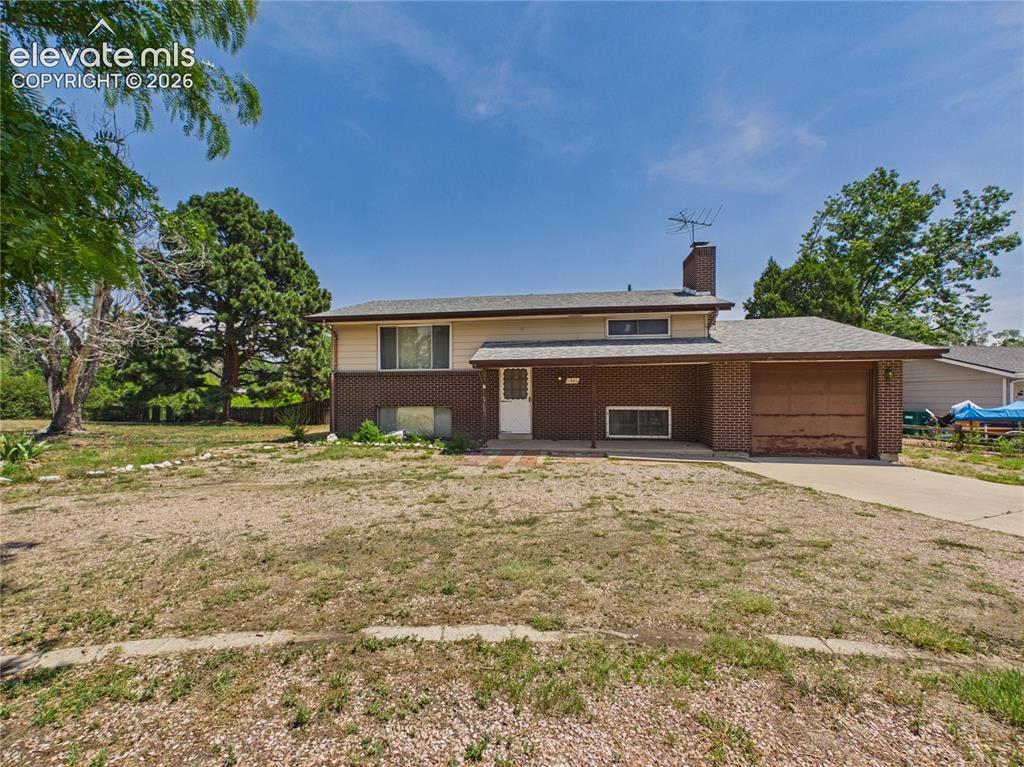 Image 33 of 50: Classic brick-and-siding exterior with a covered front entry, attached gara