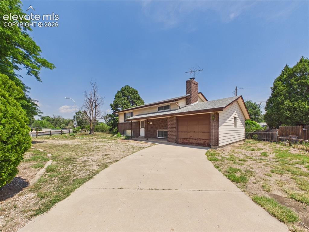 Image 34 of 50: Wide concrete driveway leads to the attached one-car garage, providing conv