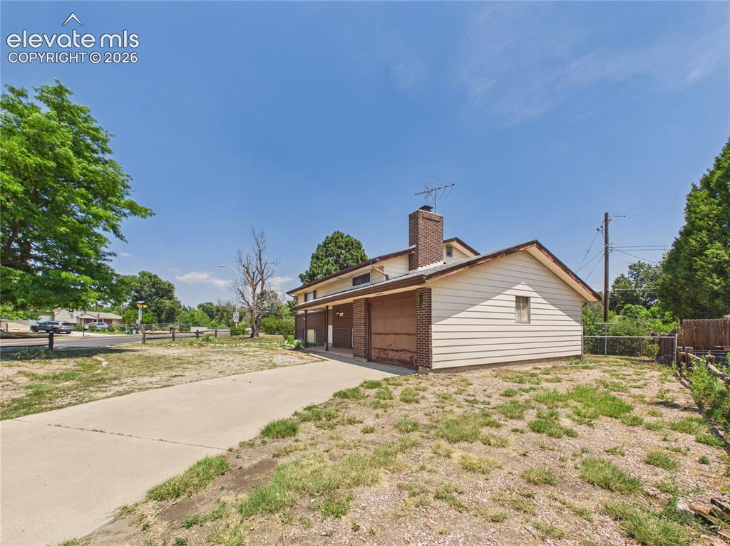 Image 42 of 50: Side Yard – Another view of the generous yard highlights mature shade trees