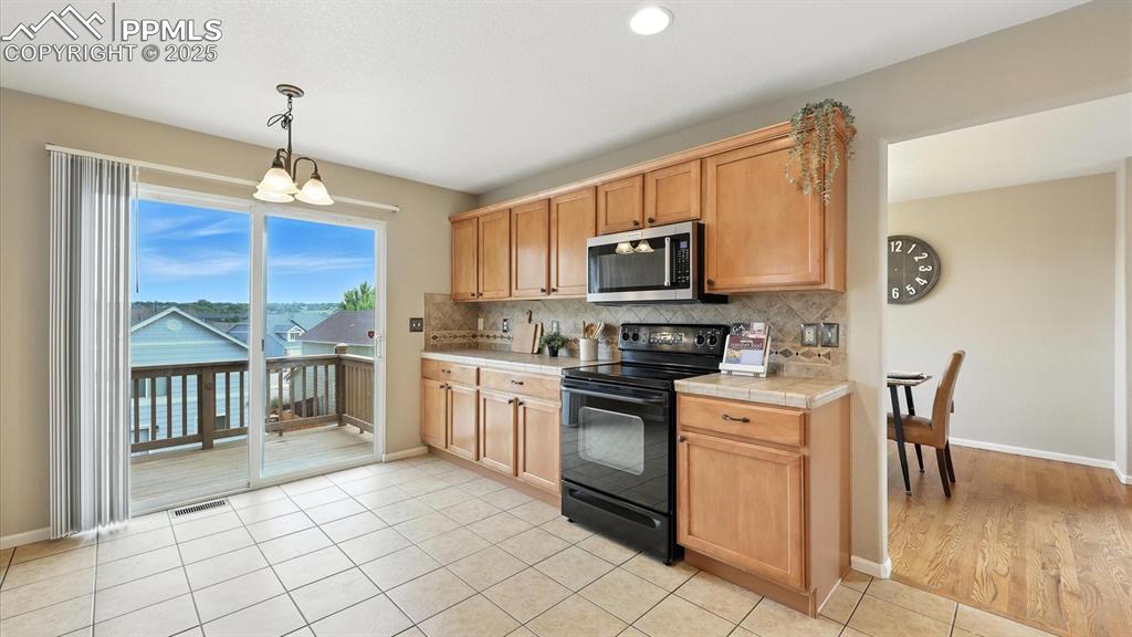 Image 11 of 50: The tiled Kitchen has a slider out to the backyard deck, ideal for outdoor 