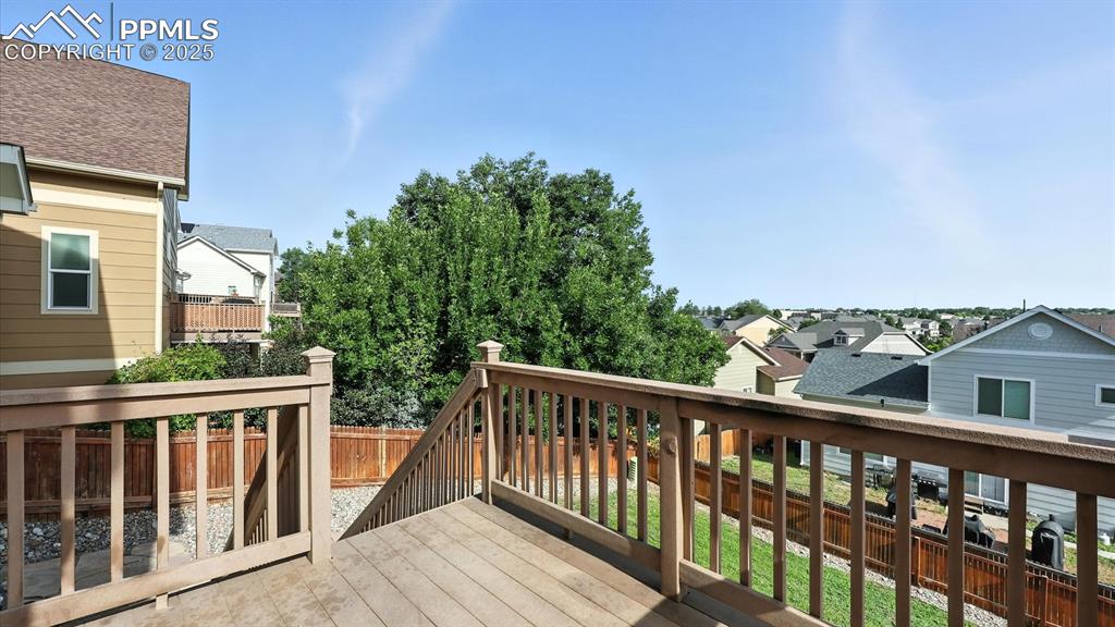 Image 13 of 50: The backyard deck located off the Kitchen has stairs to the fenced backyard