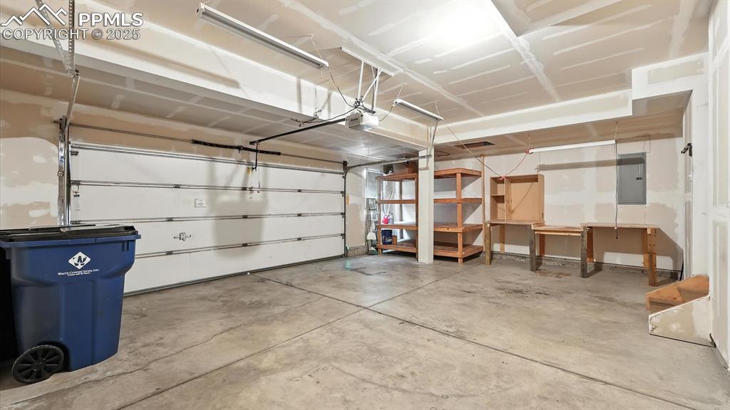 Image 19 of 50: Oversized 2-car attached garage with storage and door opener.