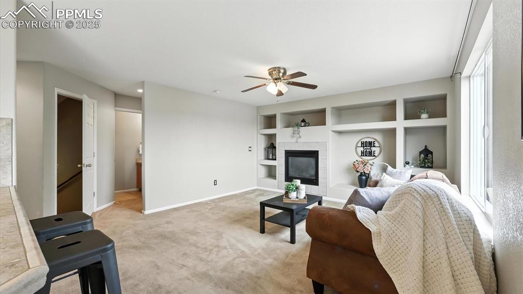 Image 21 of 50: The Family Rm features neutral carpet, a gas fireplace, built-in entertainm