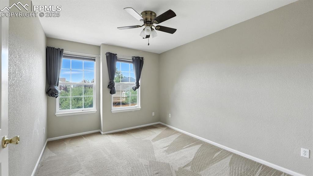 Image 24 of 50: Upper Level Bedroom #1 with neutral carpet, lighted ceiling fan, and walk i