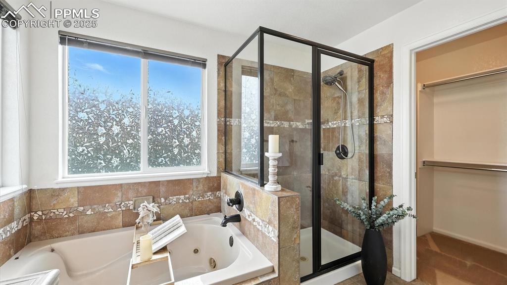 Image 33 of 50: Jetted tub, separate shower, and walk in closet in the 5pc Primary Bathroom