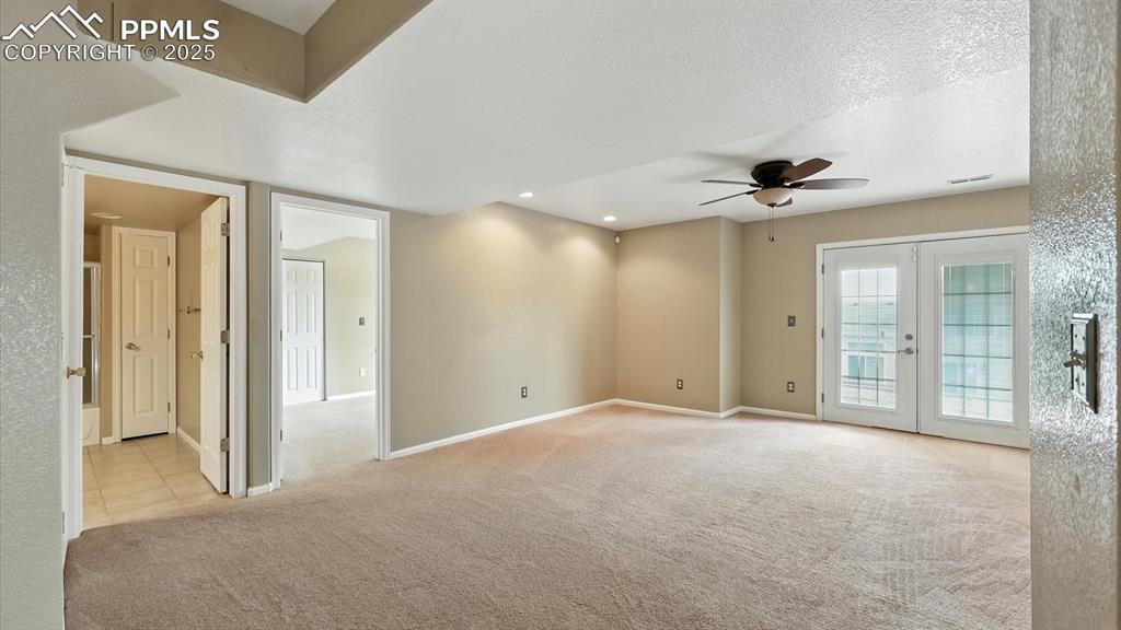 Image 38 of 50: Basement Family/Rec Room with French doors to the covered backyard flagston