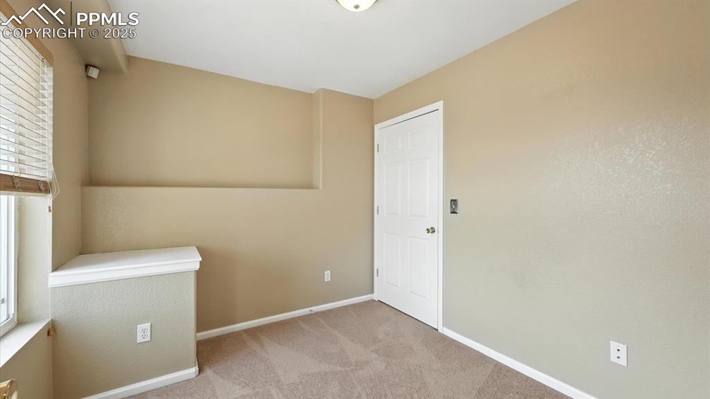 Image 42 of 50: Basement Home Office with neutral carpet.