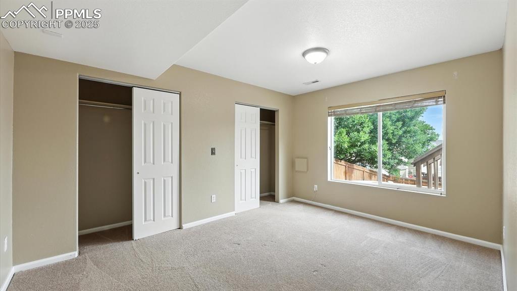 Image 44 of 50: Basement Bedroom #4 with neutral carpet and double closets.