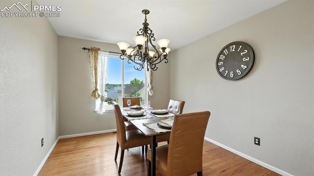 Image 9 of 50: Entertain in the elegant formal Dining Rm with wood floors, a stylish light