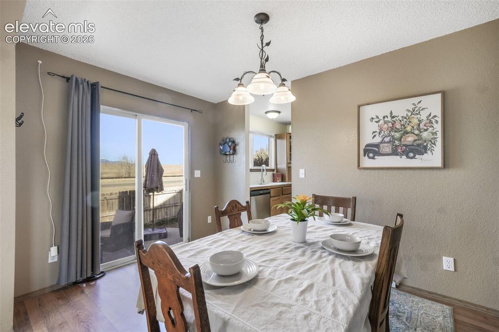 Image 11 of 50: Dining area featuring wood-finish flooring, a contemporary chandelier, and