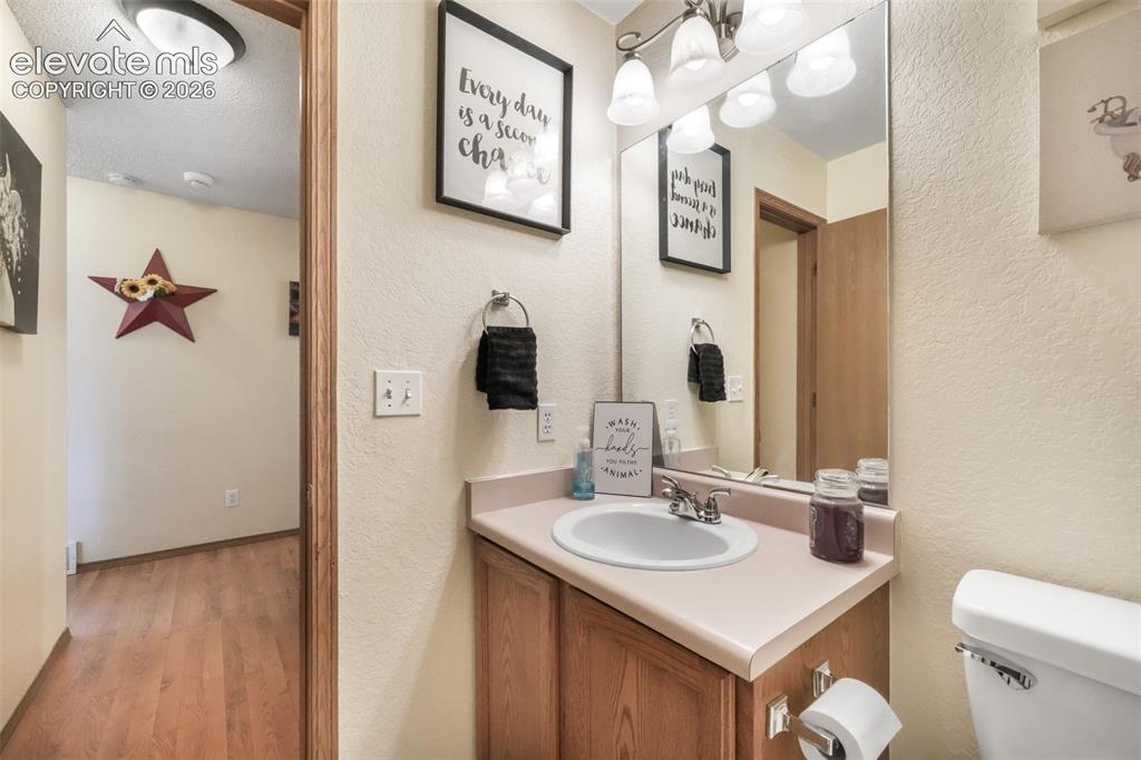 Image 19 of 50: Bathroom vanity featuring a single basin sink with chrome faucet, light woo