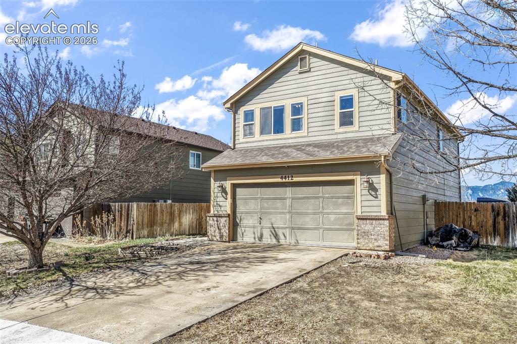 Image 2 of 50: Two-story residence featuring horizontal siding, a gabled roofline, and an