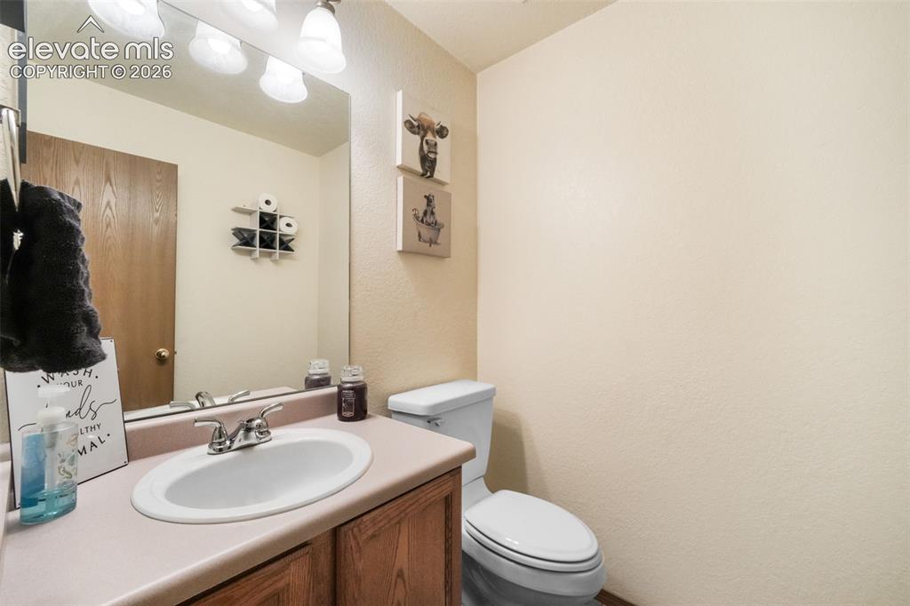 Image 20 of 50: Vanity with integrated sink, chrome faucet, and wood-finish cabinetry