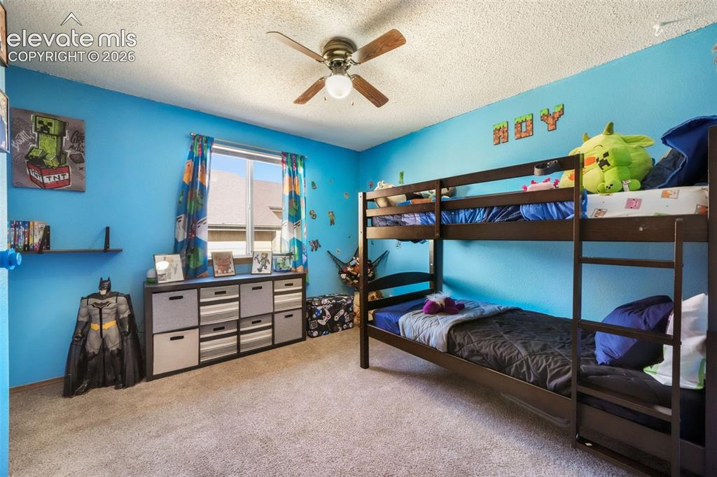 Image 24 of 50: Carpeted room featuring a ceiling fan with integrated lighting, a window wi