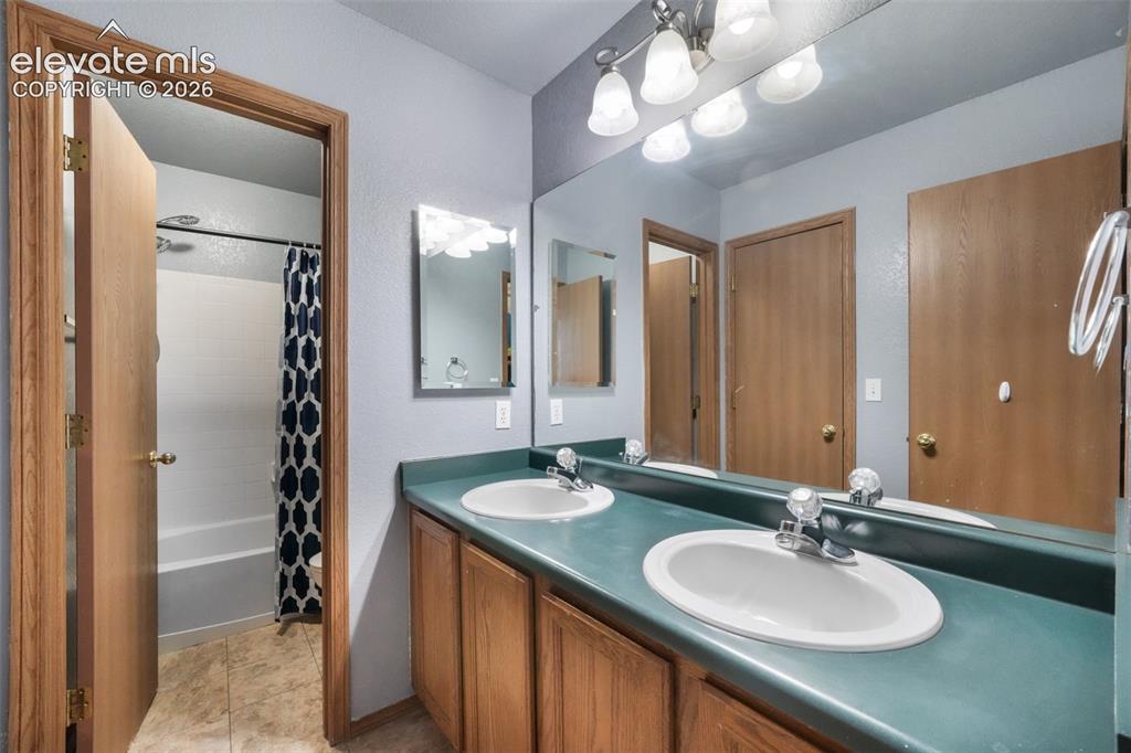 Image 27 of 50: Bathroom featuring a double vanity with two oval sinks and a large wall-mou