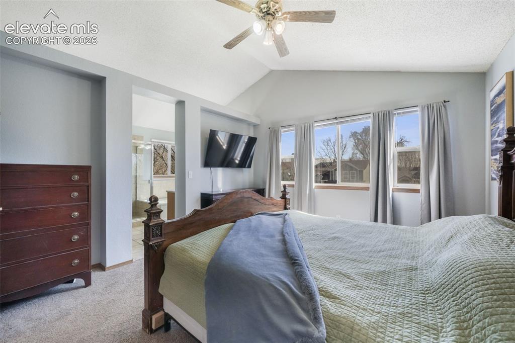 Image 30 of 50: Vaulted ceiling with ceiling fan, multiple windows with window treatments,