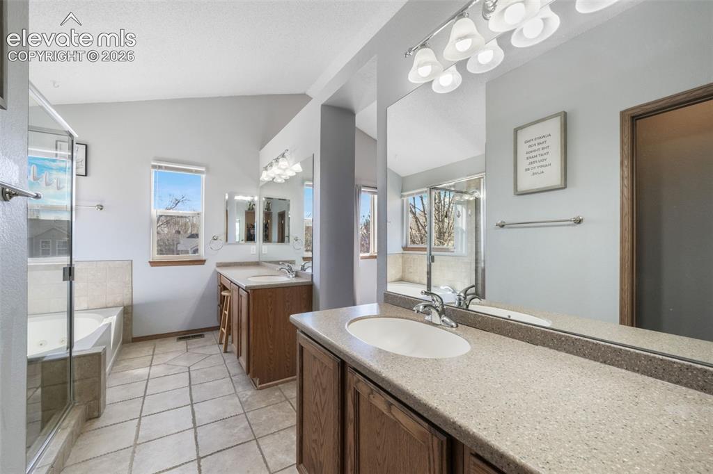 Image 36 of 50: Spacious bathroom featuring a dual vanity with integrated sinks, light-tone