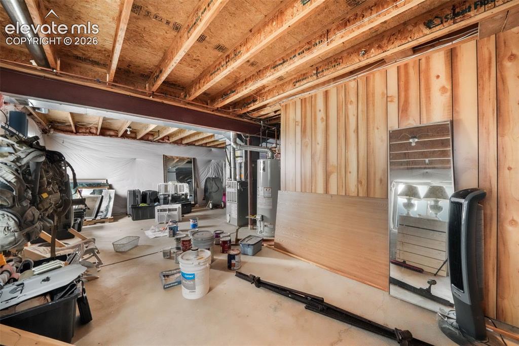 Image 39 of 50: Unfinished lower level featuring exposed wood joists and a concrete floor