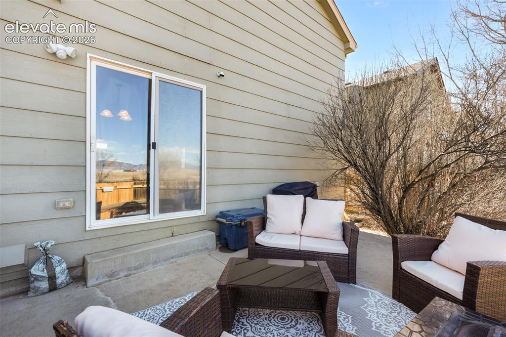 Image 42 of 50: Concrete patio featuring a sliding glass door and exterior light fixtures
