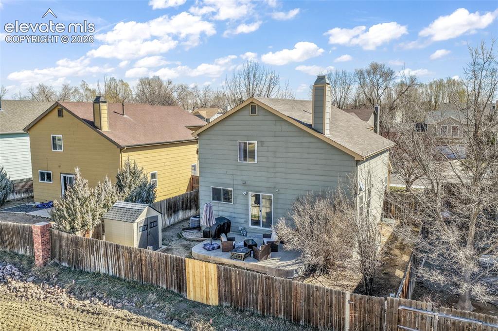 Image 46 of 50: Rear exterior featuring a patio, sliding glass door access, an outdoor stor