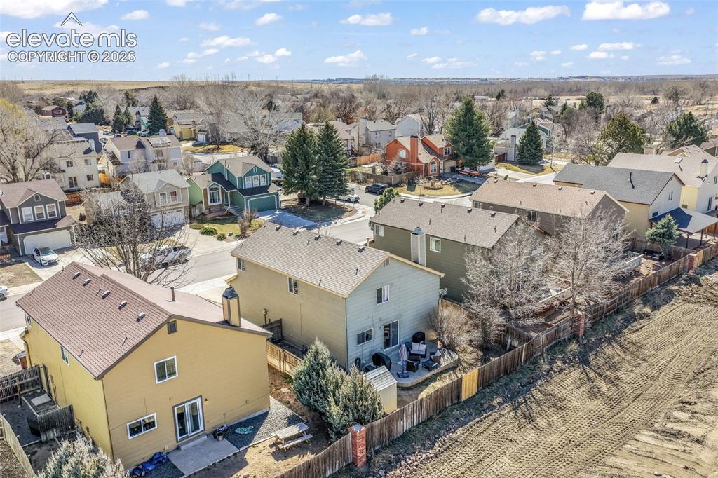 Image 47 of 50: Residential property featuring a light-colored exterior, brown roofing, and