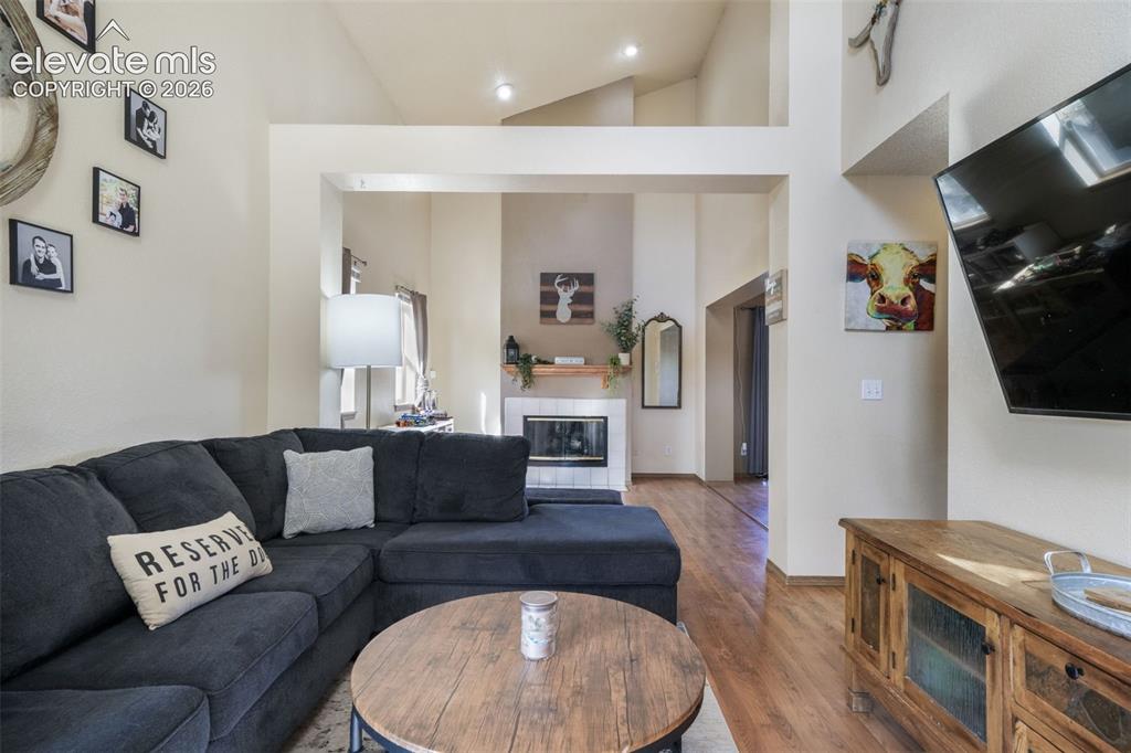 Image 6 of 50: Vaulted ceilings in a living area featuring wood-finish flooring, a built-i