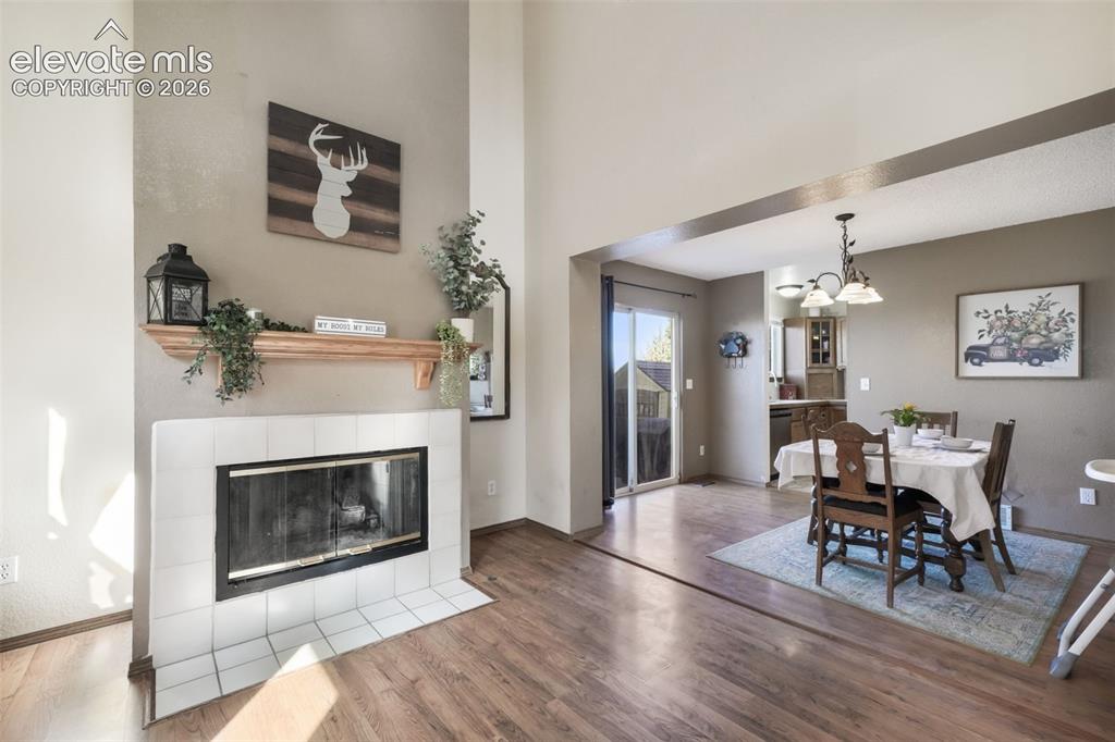 Image 9 of 50: Vaulted ceiling living area featuring a fireplace with white tile surround