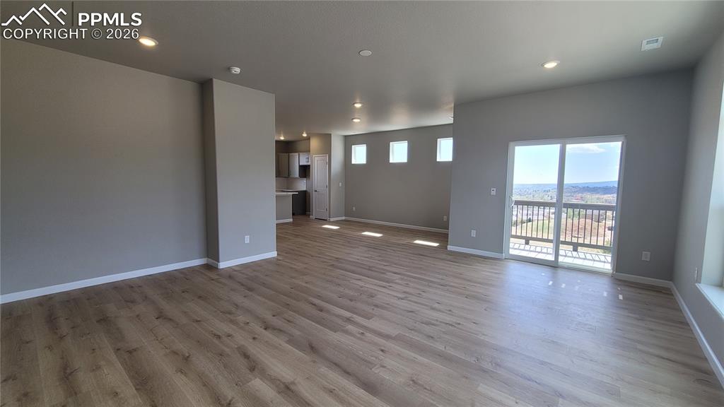 Image 21 of 39: Living room with LVP flooring, LED Lighting, Walk-Out to Deck-Incredible Vi