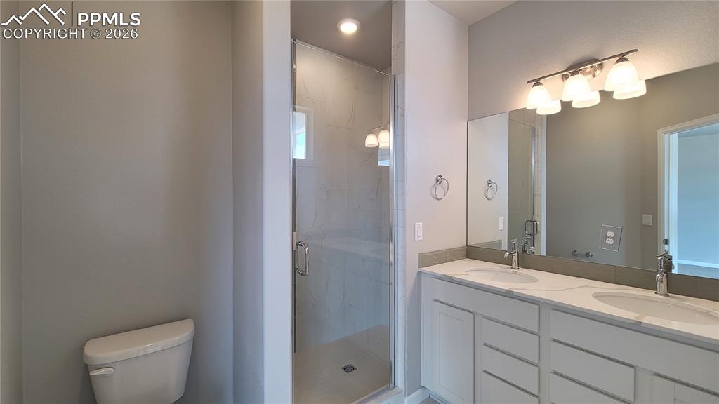 Image 29 of 39: Primary walk-in closet with wood shelving and rods! 