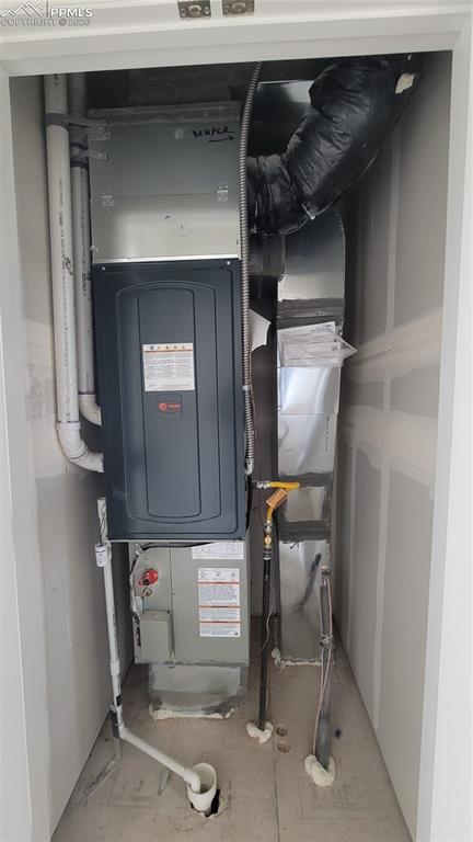 Image 37 of 39: Utility closet at entry level with tankless water heater! 